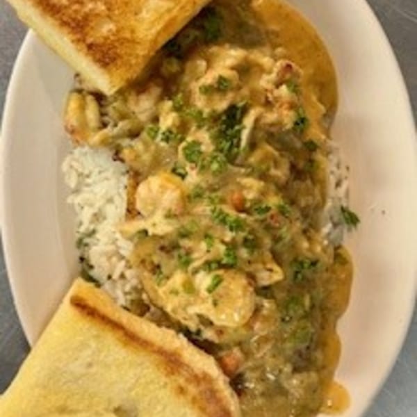 Krawfish Kai's seafood etouffee with rice and toasted bread on a white plate.