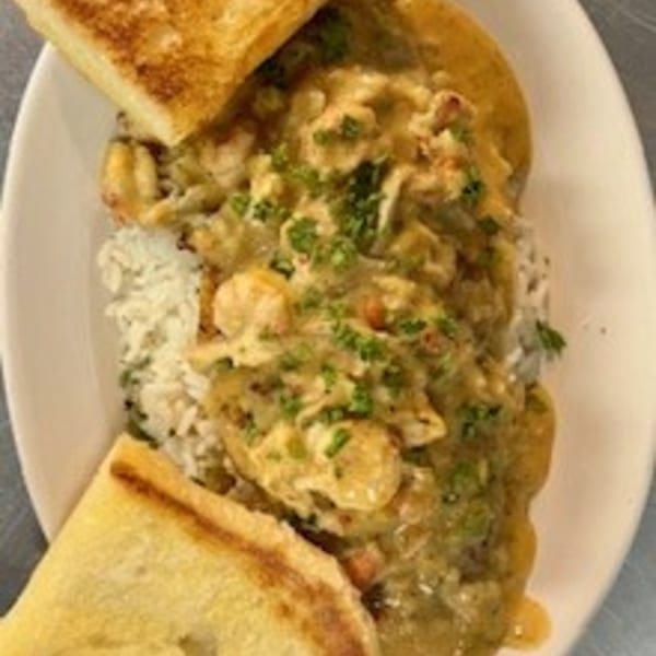 Krawfish Kai's seafood etouffee with rice, topped with parsley and served with toasted bread.