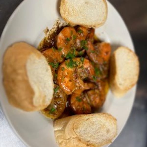 Krawfish Kai's shrimp scampi with garlic, herbs, and lemon, served with toasted bread slices.
