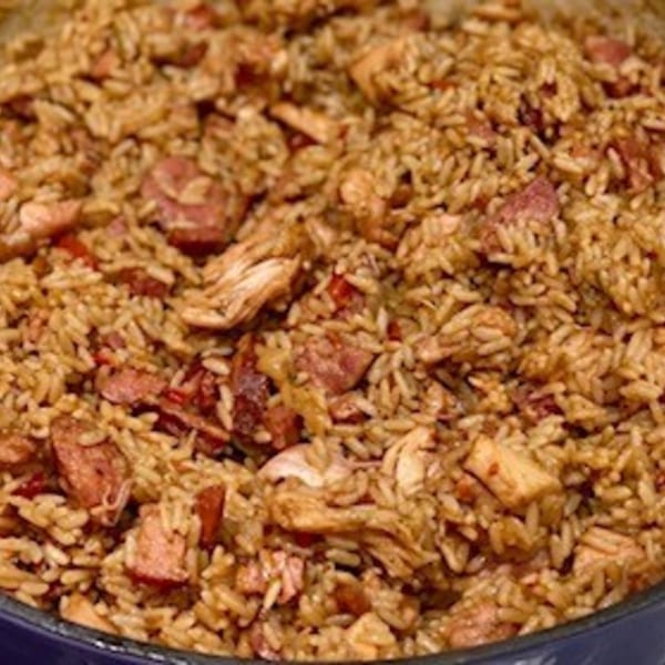 Close-up of Krawfish Kai's jambalaya, featuring rice, chicken, and sausage in a dark pot.